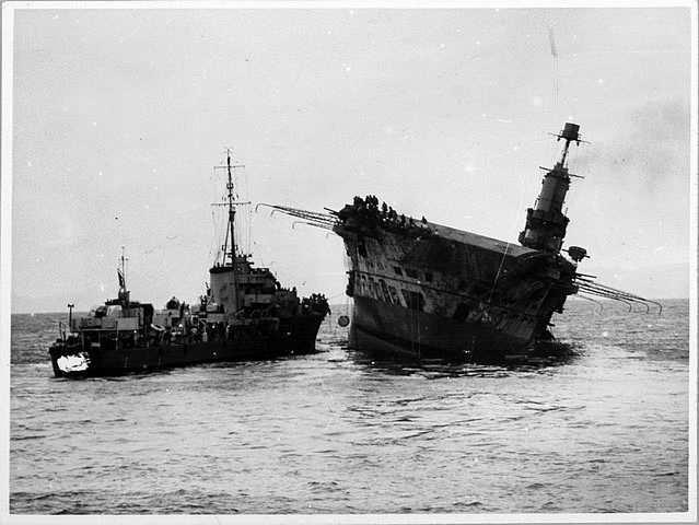 Los destructores de escolta se preparan para rescatar a la tripulación del Ark Royal, la escora del barco ya es evidente
